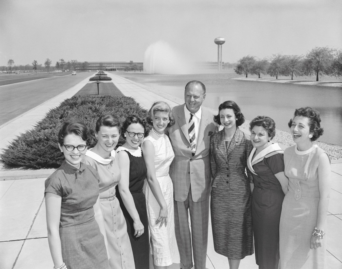 Harley Earl with the “Damsels of Design” with the GM Tech Center’s stainless-steel water tower in the background.